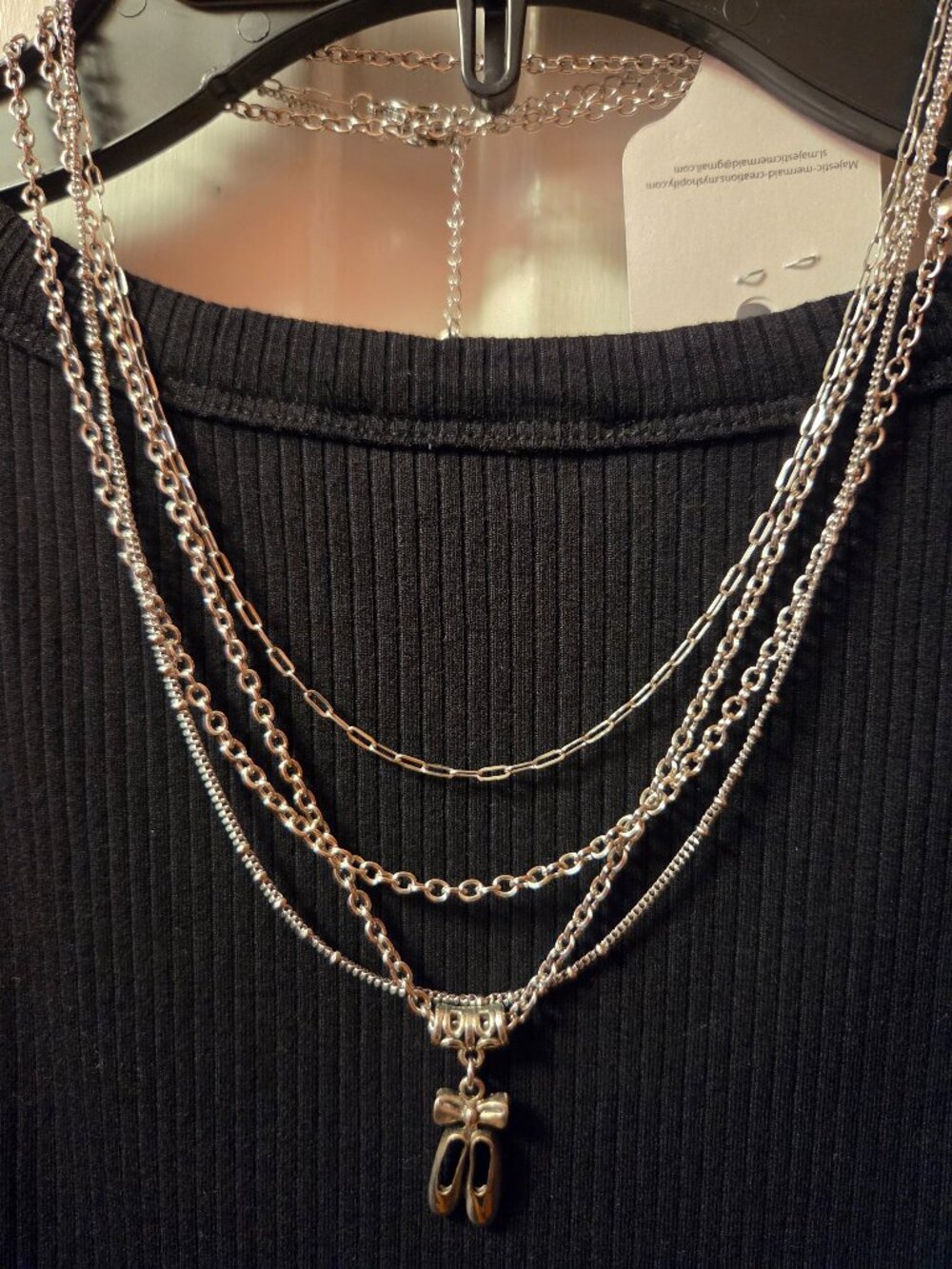 Multiple slivertone Necklaces one has a pair of Ballet Slippers.